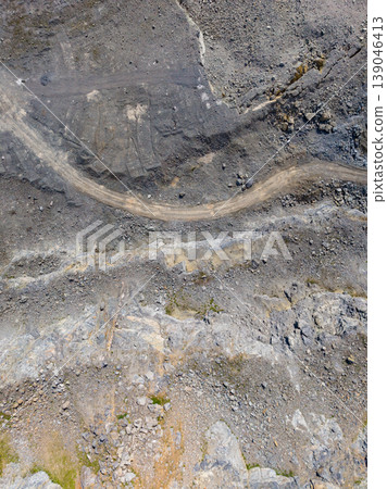 Granite quarry site with a dirt road and rocky terrain in the daytime during a clear sky away from urban areas 139046413