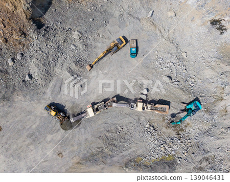 Granite quarry operation with heavy machinery and equipment at work in a mining site showing extraction activity from above Granite quarry operation with heavy machinery and equipment at work in a mining site showing extraction activity from above 139046431