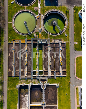 Water treatment facility shows tanks and processing areas in operation during a sunny day in a city Water treatment facility shows tanks and processing areas in operation during a sunny day in a city 139046524