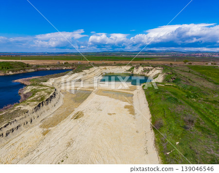 Wide view of sandy area surrounded by water and grasslands under a blue sky in a rural setting during daytime Wide view of sandy area surrounded by water and grasslands under a blue sky in a rural setting during daytime 139046546