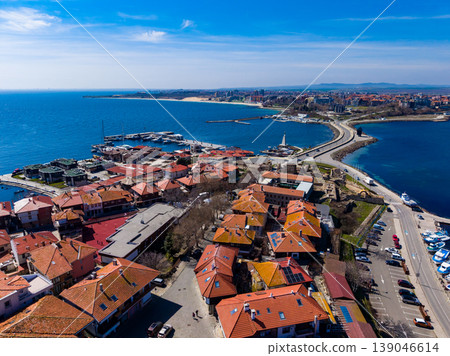 Coastal view of a port town with houses and boats near the water during a sunny day at midday Coastal view of a port town with houses and boats near the water during a sunny day at midday 139046614