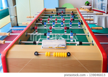 Playing table football in a children's playroom Playing table football in a children's playroom 139046813