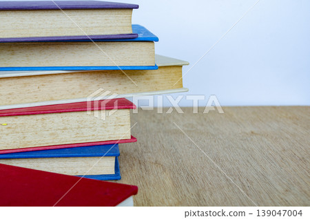 Stack of books on wooden table representing study and knowledge, with customizable space for text. Stack of books on wooden table representing study and knowledge, with customizable space for text. 139047004