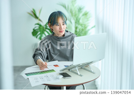 Woman working at table Woman working at table 139047054