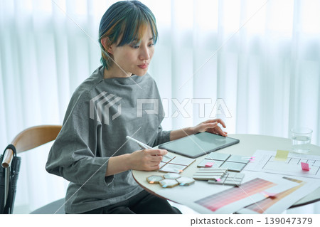 A female designer checks material samples and color charts. A female designer checks material samples and color charts. 139047379