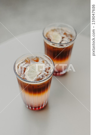 Two glasses with refreshing summer cocktails on a table. Two glasses with refreshing summer cocktails on a table. 139047686