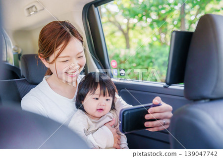 A mother riding in a taxi with her young child A mother riding in a taxi with her young child 139047742