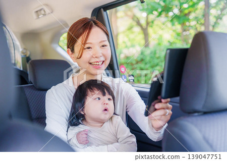 A mother riding in a taxi with her young child A mother riding in a taxi with her young child 139047751