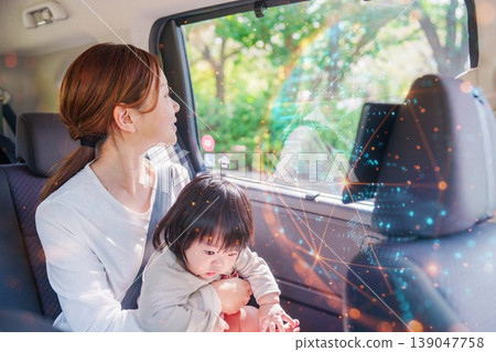 A mother riding in a taxi with her young child 139047758