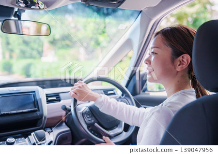 A young woman driving a car with a smile A young woman driving a car with a smile 139047956