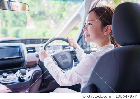 A young woman driving a car with a smile A young woman driving a car with a smile 139047957
