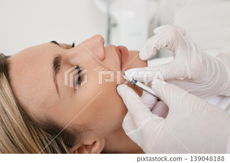 Beautician doing injection into nasolabial folds to female patient. Correction of wrinkles on woman face using dermal fillers 139048188