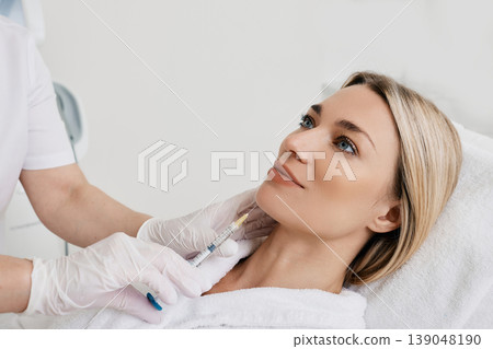 Facelift woman chin and lower face using beauty injection, non surgery. Process lifting face contour at cosmetology, close-up Facelift woman chin and lower face using beauty injection, non surgery. Process lifting face contour at cosmetology, close-up 139048190