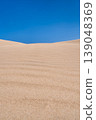 sand dune against a blue spring sky, clean, empty sandy beaches awaiting vacationers, vertical poster with copy space 139048369