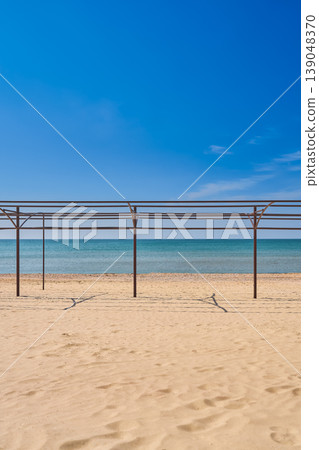 beach awaiting tourists and vacationers, empty frames for tents on a sandy beach, a Mediterranean vacation, vertical photo 139048370