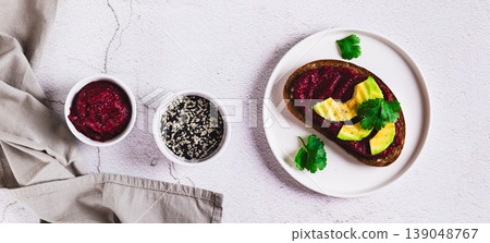 Toasts with homemade vegetarian beet hummus on a plate on the table top view web banner Toasts with homemade vegetarian beet hummus on a plate on the table top view web banner 139048767