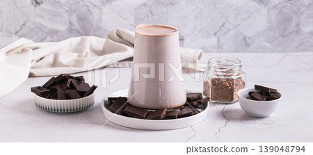 Warm cocoa drink in a glass and chocolate on a plate on the table web banner 139048794
