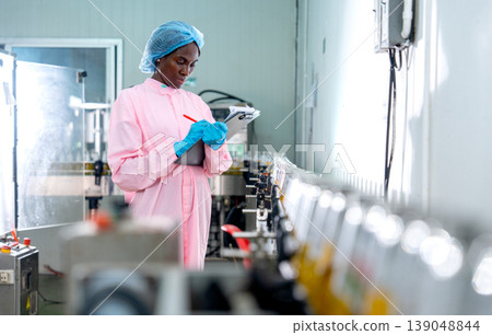 African American woman factory worker write the detail and check follow the standard checklists on document file for the quality of product in the bottle in line productivity in drinking industrial African American woman factory worker write the detail and check follow the standard checklists on document file for the quality of product in the bottle in line productivity in drinking industrial 139048844