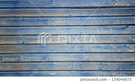 Wooden surface painted blue with visible texture and grain during daylight hours Wooden surface painted blue with visible texture and grain during daylight hours 139049075