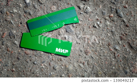 Green payment card lies broken on a dirty street in a busy city 139049217