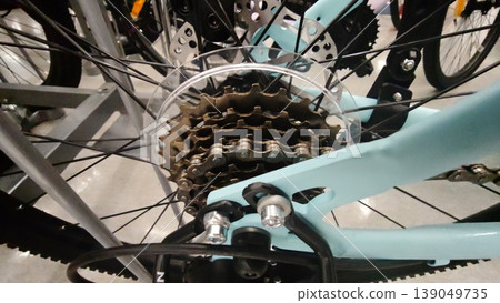 Looking at a bicycle gear system in a store display with many bikes around Looking at a bicycle gear system in a store display with many bikes around 139049735