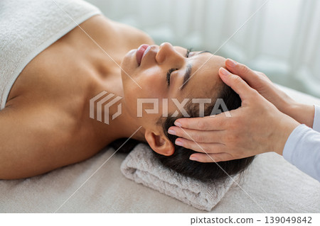 Close up of African American woman receiving head massage at spa 139049842