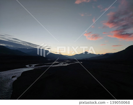 Panoramic view of a winding mountain river at sunset with pink clouds in the sky. Panoramic view of a winding mountain river at sunset with pink clouds in the sky. 139050068