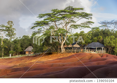 Seven Colored Earth with tropical forest in background and wooden house Seven Colored Earth with tropical forest in background and wooden house 139050104