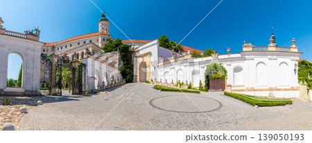 The Mikulov castle, Czech republic. Famous medieval castle on top of hill. Beautiful ornament garden with flowers, trees and green grass. Summer weather and blue sky. Beautiful wine region near Palava The Mikulov castle, Czech republic. Famous medieval castle on top of hill. Beautiful ornament garden with flowers, trees and green grass. Summer weather and blue sky. Beautiful wine region near Palava 139050193