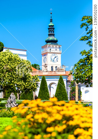 The Mikulov castle, Czech republic. Famous medieval castle on top of hill. Beautiful ornament garden with flowers, trees and green grass. Summer weather and blue sky. Beautiful wine region near Palava The Mikulov castle, Czech republic. Famous medieval castle on top of hill. Beautiful ornament garden with flowers, trees and green grass. Summer weather and blue sky. Beautiful wine region near Palava 139050200