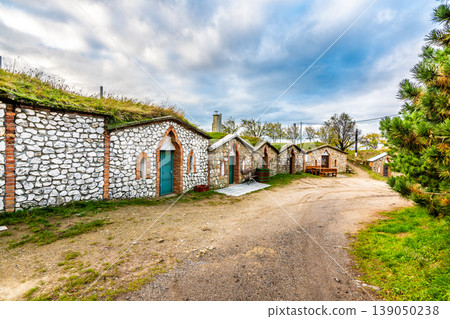 Traditional historical wine cellar at Vrbice village, South Moravia region - Czech Republic. Small wine houses with plants over roof, built in the ground. Dramatic clouds, autumn weather. Traditional historical wine cellar at Vrbice village, South Moravia region - Czech Republic. Small wine houses with plants over roof, built in the ground. Dramatic clouds, autumn weather. 139050238