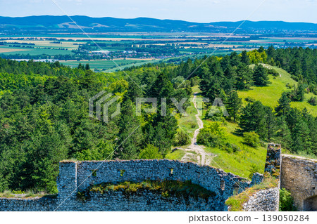 The old ruins of castle Cachtice (Cachtice in local speak). Ruined castle on top of hill at Slovakia. Famous and mysterious place known from legend of blood lady Bathory. Summer day, panorama view. The old ruins of castle Cachtice (Cachtice in local speak). Ruined castle on top of hill at Slovakia. Famous and mysterious place known from legend of blood lady Bathory. Summer day, panorama view. 139050284