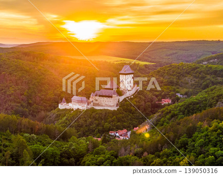 Aerial view of beautiful sunset over the Karlstejn castle, Czech Republic. Drone shot of ancient castle with near forest. Castle in gothic style was build by emperor of Rome rise, Charles IV. 139050316
