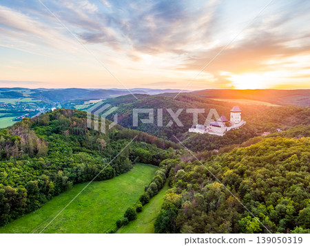 Aerial view of beautiful sunset over the Karlstejn castle, Czech Republic. Drone shot of ancient castle with near forest. Castle in gothic style was build by emperor of Rome rise, Charles IV. 139050319