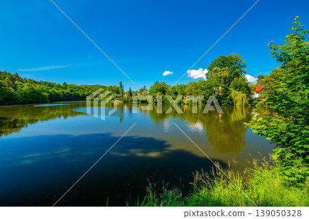Small lake and fish pond near Mnisek pod Brdy chateau. Summer day with blue sky Small lake and fish pond near Mnisek pod Brdy chateau. Summer day with blue sky 139050328