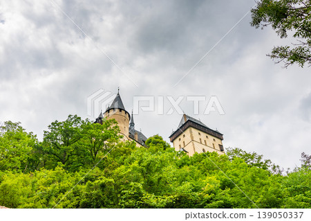 Famous medieval gothic castle Karlstejn on top of the hill. Beautiful stronghold is built by king Charles IV. Historical national heritage of Czech Republic is placed near Prague city. Cloudy weather 139050337