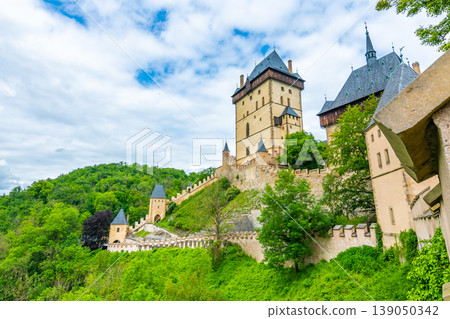 Famous medieval gothic castle Karlstejn on top of the hill. Beautiful stronghold is built by king Charles IV. Historical national heritage of Czech Republic is placed near Prague city. Cloudy weather Famous medieval gothic castle Karlstejn on top of the hill. Beautiful stronghold is built by king Charles IV. Historical national heritage of Czech Republic is placed near Prague city. Cloudy weather 139050342