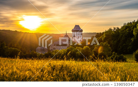 Beautiful sunset over famous Czech Republic castle, the Karlstejn. Medieval castle built in gothic style by king and emperor of old Roman rise, Charles IV. Dramatic sky, vibrant colors. 139050347