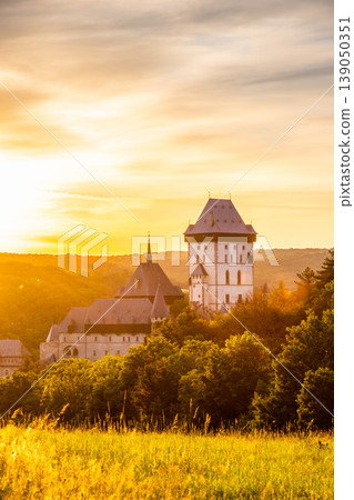 Beautiful sunset over famous Czech Republic castle, the Karlstejn. Medieval castle built in gothic style by king and emperor of old Roman rise, Charles IV. Dramatic sky, vibrant colors. 139050351