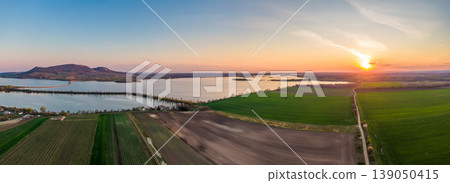 Panoramic aerial view of Palava hills, czech republic. Vineyard land near water reservoir Nove mlyny. Concept of agriculture and wine production. Summer weather, vibrant colors at sunset time. Panoramic aerial view of Palava hills, czech republic. Vineyard land near water reservoir Nove mlyny. Concept of agriculture and wine production. Summer weather, vibrant colors at sunset time. 139050415