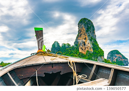 View from boat going to famous Railay beach, Krabi Thailand. Coastline of Andaman sea, famous tourist and backpacker target. Tropical paradise, exotic vacation. Cloudy weather in summer day View from boat going to famous Railay beach, Krabi Thailand. Coastline of Andaman sea, famous tourist and backpacker target. Tropical paradise, exotic vacation. Cloudy weather in summer day 139050577
