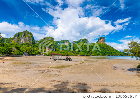 Panoramic view of east Railay beach, Krabi town, Thailand. Landscape with tractor in foreground and huge limestone rocks in background. Summer day, blue sky. 139050617