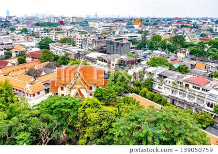 Panorama view of Bangkok city, Thailand. Cityscape of residental buildings in foreground, temples, skyscrapers and modern buildings in far. Fresh trees and plants. Cloudy weather, dramatic clouds. Panorama view of Bangkok city, Thailand. Cityscape of residental buildings in foreground, temples, skyscrapers and modern buildings in far. Fresh trees and plants. Cloudy weather, dramatic clouds. 139050759