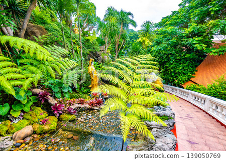 Stars leading to the Wat Saket temple (Golden mount) in Bangkok city, Thailand. Beautiful trees and plants with flowers on the side. Buddhism religion statues near the stairs. Spiritual place Stars leading to the Wat Saket temple (Golden mount) in Bangkok city, Thailand. Beautiful trees and plants with flowers on the side. Buddhism religion statues near the stairs. Spiritual place 139050769