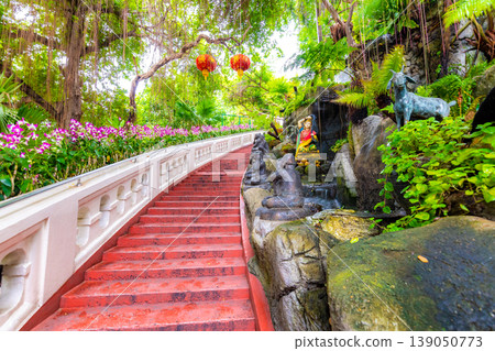 Stars leading to the Wat Saket temple (Golden mount) in Bangkok city, Thailand. Beautiful trees and plants with flowers on the side. Buddhism religion statues near the stairs. Spiritual place Stars leading to the Wat Saket temple (Golden mount) in Bangkok city, Thailand. Beautiful trees and plants with flowers on the side. Buddhism religion statues near the stairs. Spiritual place 139050773