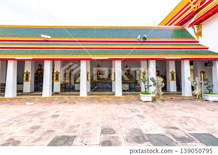 Wat Pho temple in Bangkok city, Thailand. Famous spiritual buddhism building with colorful roof. Beautiful statues on the side Wat Pho temple in Bangkok city, Thailand. Famous spiritual buddhism building with colorful roof. Beautiful statues on the side 139050795