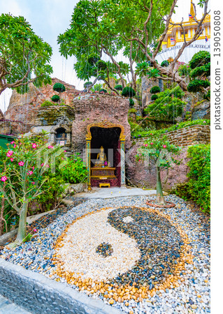 Yin Yang symbol placed in buddhist garden near the Wat Saket temple, Bangkok city, Thailand. Spiritual symbol is placed near the Buddha statue near fresh trees and flowers. Meditation and harmony. 139050808