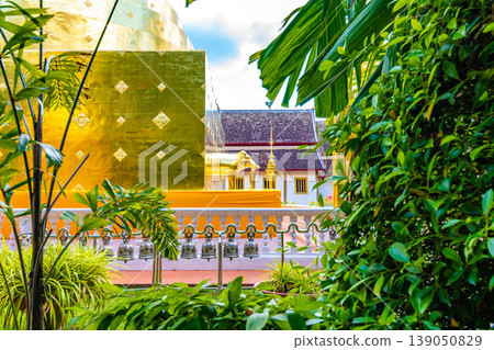 Golden statue of elephant placed on Wat Phra Singh temple in Chiang Mai,Thailand. Beautiful buddhist symbol, famous tourist destination. Ancient sculpture in small parkland. Religion and spirituality Golden statue of elephant placed on Wat Phra Singh temple in Chiang Mai,Thailand. Beautiful buddhist symbol, famous tourist destination. Ancient sculpture in small parkland. Religion and spirituality 139050829