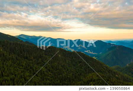 Aerial view to Mala Fatra mountains in Slovakia. Sunrise above mountain peaks and hills in far. Beautiful nature, vibrant colors. Famous tourist destination for hiking and trekking. Cloudy weather. Aerial view to Mala Fatra mountains in Slovakia. Sunrise above mountain peaks and hills in far. Beautiful nature, vibrant colors. Famous tourist destination for hiking and trekking. Cloudy weather. 139050864
