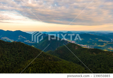 Aerial view to Mala Fatra mountains in Slovakia. Sunrise above mountain peaks and hills in far. Beautiful nature, vibrant colors. Famous tourist destination for hiking and trekking. Cloudy weather. Aerial view to Mala Fatra mountains in Slovakia. Sunrise above mountain peaks and hills in far. Beautiful nature, vibrant colors. Famous tourist destination for hiking and trekking. Cloudy weather. 139050865